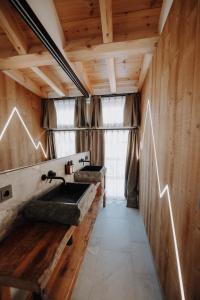 baño con lavabo de piedra y paredes de madera. en Bergchalets Gut Wenghof, en Werfenweng