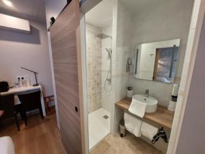 a bathroom with a sink and a shower at Logis Hôtels - Hôtel et Restaurant Les Voyageurs in Tournon-dʼAgenais