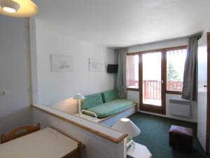 een woonkamer met een groene bank en een raam bij Appartement cosy 4 pers, navette proche, balcon - Alpe d'Huez - FR-1-405-166 in Huez