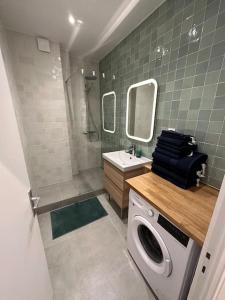 La salle de bains est pourvue d'un lave-linge et d'un lavabo. dans l'établissement Paris Auteuil/Rolland Garros, à Boulogne-Billancourt