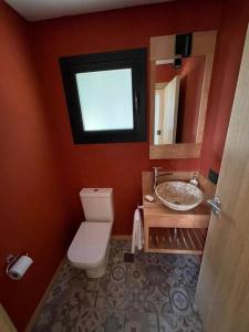 a bathroom with a toilet and a sink and a window at Chapelco Golf - Cabaña a Estrenar in San Martín de los Andes