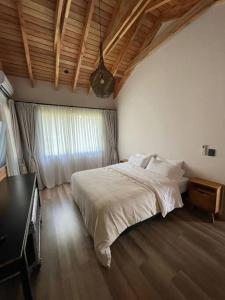 a bedroom with a large bed and a window at Chapelco Golf - Cabaña a Estrenar in San Martín de los Andes