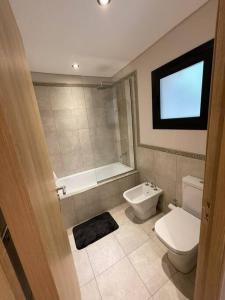 a bathroom with a toilet and a tub and a sink at Chapelco Golf - Cabaña a Estrenar in San Martín de los Andes