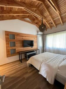 sypialnia z łóżkiem i telewizorem z płaskim ekranem w obiekcie Chapelco Golf - Cabaña a Estrenar w mieście San Martín de los Andes