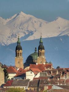 a group of buildings with snowy mountains in the background at Apartament Anca in Sibiu