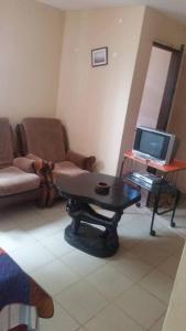 een woonkamer met een bank, een tafel en een laptop bij #4 princess self catering apartments, Senegambia area in Sere Kunda