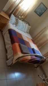 a bed with a colorful blanket on it in a room at #4 princess self catering apartments, Senegambia area in Sere Kunda