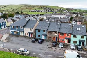 Central Dingle Stay في دينغل: مدينة صغيرة فيها سيارات متوقفة في موقف للسيارات