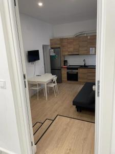 a living room with a table and a kitchen at U1 Ap Nuevo, bien comunicado Madrid centro in Madrid