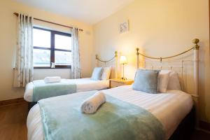 a hotel room with two beds and a window at Central Dingle Stay in Dingle