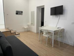 a living room with a table and a tv on a wall at U1 Ap Nuevo, bien comunicado Madrid centro in Madrid