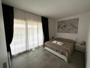 a bedroom with a bed and a large window at La Residenza del Re! in Palau