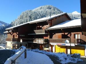 a snow covered building with a mountain in the background at Appartement rénové au cœur d'Arêches-Beaufort, proche pistes, balcon plein sud, piscine, pour 4 pers. - FR-1-342-167 in Arêches +4 photos