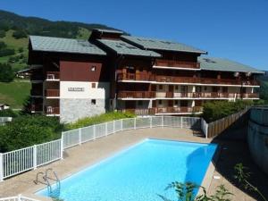 um hotel com piscina em frente a um edifício em Appartement Arêches-Beaufort, 2 pièces, 4 personnes - FR-1-342-154 em Arêches