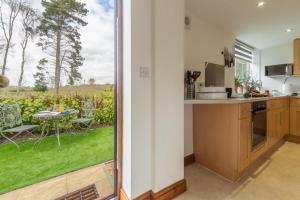 a kitchen with a view of a garden with a table at The Old Chapel in Pentney