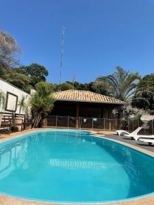 a large blue swimming pool with a gazebo at Hotel Jardim in Jardim