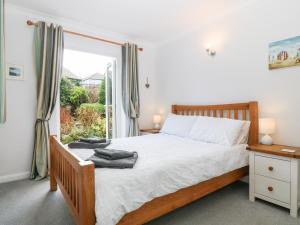 a bedroom with a bed and a window at Glan Dwr in Pentraeth