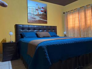 a bedroom with a bed with a blue bedspread at Casa Alegria in Cobán