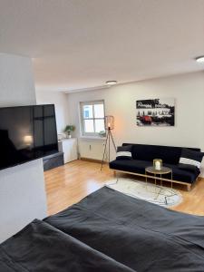 a living room with a couch and a tv at Charmante Wohnung am Hafen in Bregenz