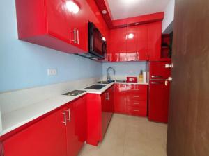 a red kitchen with white counters and red cabinets at Spacious 2 BR, fully equipped kitchen close to Ferry, Unit 5 in Catano