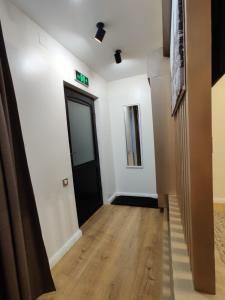 un pasillo con paredes blancas y una puerta negra en Trend Apart Hotel, en Brasov