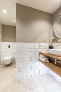 a white bathroom with a tub and a sink at Next Door in Domburg