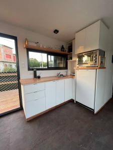 a kitchen with white cabinets and a large window at Apart Containers, Acantilados, unidad in Mar del Plata