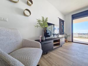 a living room with a chair and a tv at Los Alcazares Velapi - 0510 in San Javier