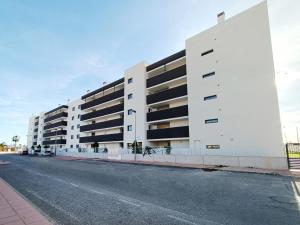 an empty street in front of a white building at Los Alcazares Velapi - 0510 in San Javier