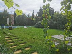 a garden with a table and a bench in the grass at La verdine in Arles +3 photos
