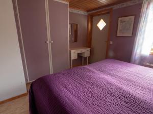 a bedroom with a purple bed and a desk at Högerödja in Hultsfred