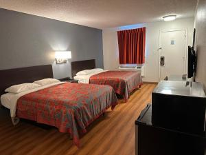 a hotel room with two beds and a sink at Sullivan Inn in Sullivan