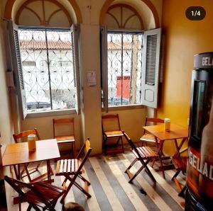 um restaurante vazio com mesas, cadeiras e janelas em Will's House em São Luís