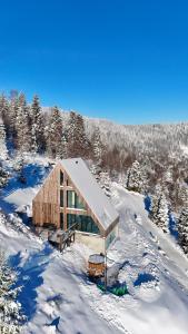 une maison au sommet d'une colline enneigée dans l'établissement Domek w Szczyrku, à Szczyrk