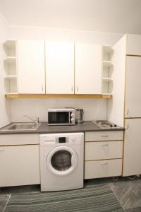 a kitchen with a washing machine and a microwave at Comfort Apartment HG in Vienna