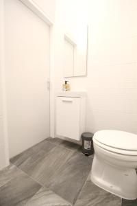 a white bathroom with a toilet and a sink at Comfort Apartment HG in Vienna