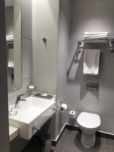 a bathroom with a white sink and a toilet at Garden Court Polokwane in Polokwane