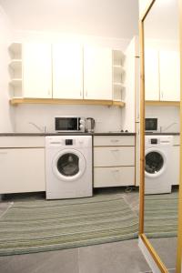 a laundry room with two washes and white cabinets at Comfort Apartment HG in Vienna