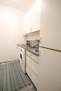 a kitchen with a white refrigerator and a washing machine at Comfort Apartment HG in Vienna