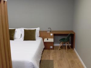 a bedroom with a bed and a green chair at Geonature in Macedo de Cavaleiros