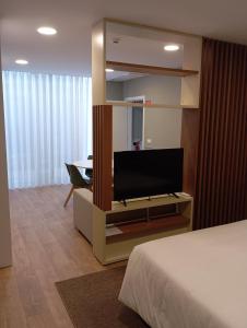 a room with a bed and a tv and a table at Geonature in Macedo de Cavaleiros