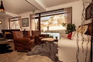 a living room with a couch and chairs and a window at Hotel Smilen in Smolyan