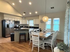 a kitchen and dining room with a table and chairs at The Sandbox in Kill Devil Hills