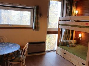 een slaapkamer met een stapelbed, een tafel en een raam bij Appartement Vars, 1 pièce, 4 personnes - FR-1-330B-115 in Vars