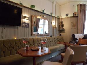 een restaurant met een bank en 2 tafels met wijnglazen bij The Rockley Hotel in Blackpool