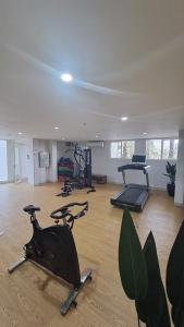 Paradise Room في Seturan: صالة ألعاب رياضية مع أجهزةٍ جري ودراجات ممارسة الرياضة في الغرفة