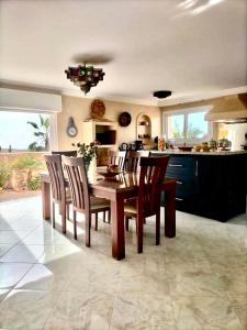 a kitchen with a wooden table and chairs and a counter at Villa targa in Mirleft +37 photos