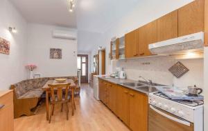 a kitchen with wooden cabinets and a table and a sink at Apartments in Porec/Istrien 10281 in Poreč