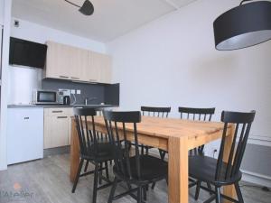 uma cozinha com uma mesa de madeira e cadeiras pretas em Studio Piau-Engaly, 1 pièce, 5 personnes - FR-1-457-175 em Aragnouet