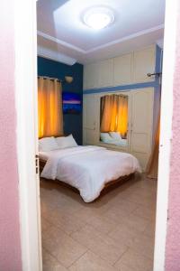 um quarto com 2 camas com paredes azuis e cortinas amarelas em Studio cosy climatisé em Lomé